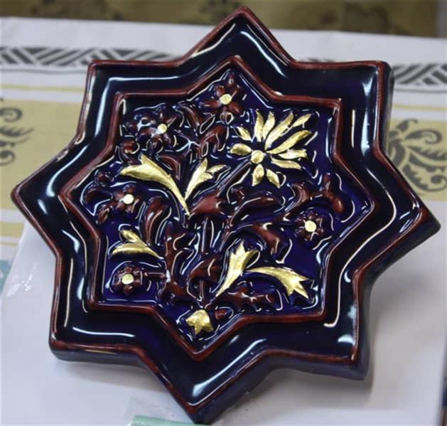 هنر سایر محفل سایر هنر ها آیه جنگجو ساخت کاشی به سبک کاشی ایلخانی سلطانیه زنجان تزیین شده با ورق طلا(ورق نازک شمش طلا با عیار 24) می باشد و طرح ان نیز مربوط به طرح های دوره مربوطه بوده و به صورت کامل مراحل پخت ان انجام و طلا در لعاب نفوذ کرده است.  ساخت این کاشی چند ماه سپری شده و با تمامی عیار های طلا تست گردیده است و در نهایت با طلای خالص ساخته شده است.